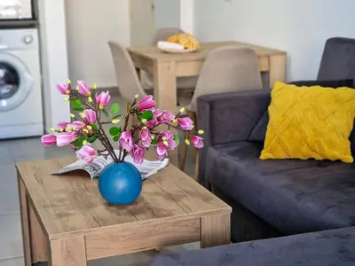 a blue vase with pink flowers on a table at AirBnSea City Centre Side Sea view Apartments in Larnaka
