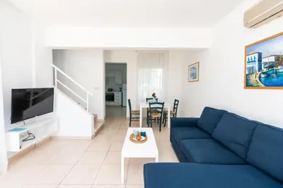 a living room with a blue couch and a table at Fig Tree Z Holiday Resort in Paralimni