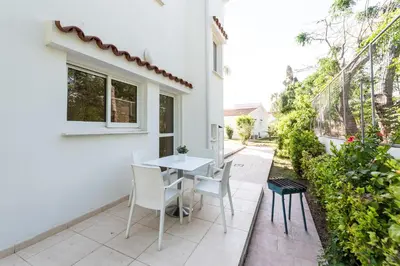 a patio with a table and chairs on the side of a house at Fig Tree Z Holiday Resort in Paralimni