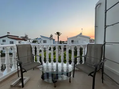 a balcony with two chairs and a glass table at Sea View Villa in Agia Thekla in Ayia Napa