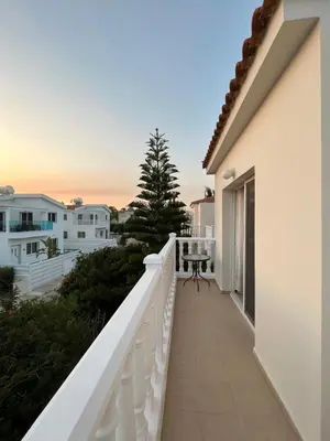 a balcony with a white railing and a tree at Sea View Villa in Agia Thekla in Ayia Napa