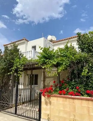 a white house with red flowers and a fence at Sea View Villa in Agia Thekla in Ayia Napa