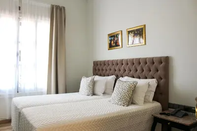 a bedroom with a large bed with white sheets and pillows at 9 Muses Hotel in Larnaka