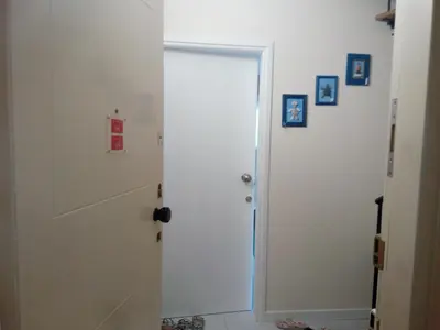 a white door leading to a hallway with pictures on the wall at Lighthouse in Larnaka