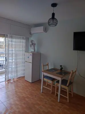 a small kitchen with a table and a refrigerator at Hawaii Royal Gardens 2 in Limassol