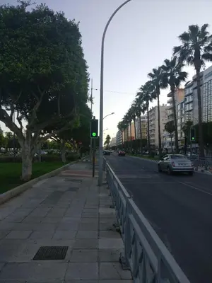 a green traffic light on a city street with palm trees at Hawaii Royal Gardens 2 in Limassol