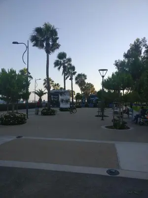 a park with palm trees and a sign in the middle at Hawaii Royal Gardens 2 in Limassol