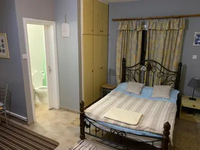 a bedroom with a bed and a bathroom with a toilet at Detached Cozy Studio in Paralimni