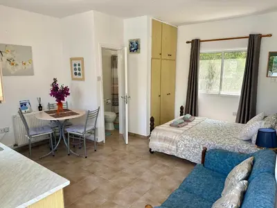 a bedroom with a bed and a table and a dining room at Detached Cozy Studio in Paralimni