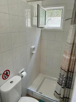 a white bathroom with a toilet and a shower at Detached Cozy Studio in Paralimni