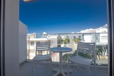 a patio with two chairs and a table on a balcony at Pavlinia Hotel & Apartments in Ayia Napa