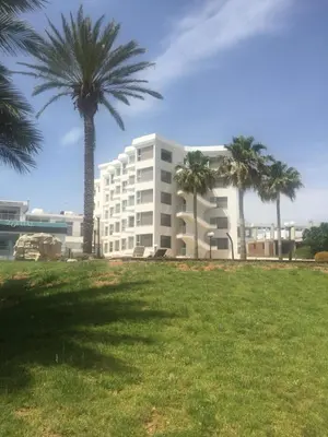 a large white building with palm trees in a park at PALLINIO COURT 402 Fig Tree Bay- Protaras Beach, IASONOS STR 7A in Protaras