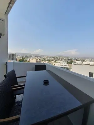 a table on a balcony with a view of a city at Great views apartment. in Limassol
