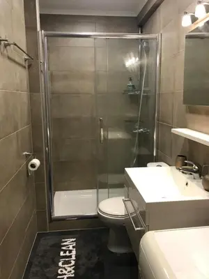 a bathroom with a shower and a toilet and a sink at Galaxy court modern apartment in Limassol