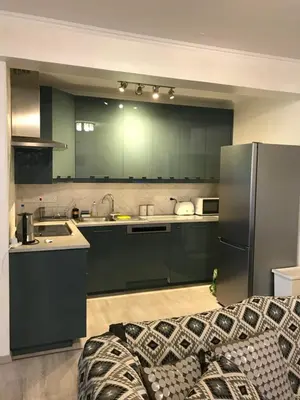 a kitchen with green cabinets and a stainless steel refrigerator at Galaxy court modern apartment in Limassol
