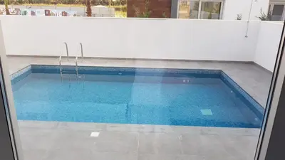 a swimming pool with blue water in a building at Mobina Villas in Larnaka
