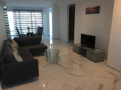 a living room with a television and a couch and a table at Mobina Villas in Larnaka