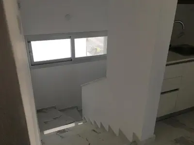 an empty room with a window and a staircase at Mobina Villas in Larnaka