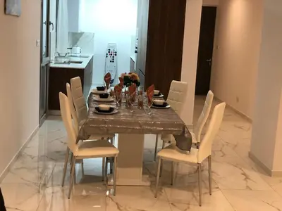 a dining room table with white chairs and a table and chairsktop at Mobina Villas in Larnaka