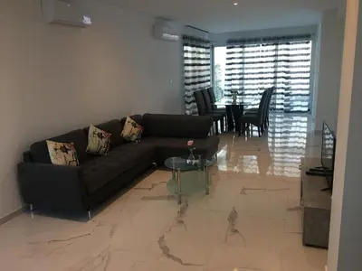 a living room with a couch and a table at Mobina Villas in Larnaka
