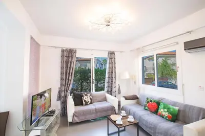a living room with a couch and a tv at Villa Papantonia in Protaras