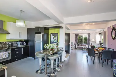 a kitchen and living room with a table and chairs at Villa Papantonia in Protaras