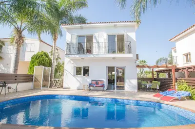 a villa with a swimming pool in front of a house at Villa Papantonia in Protaras