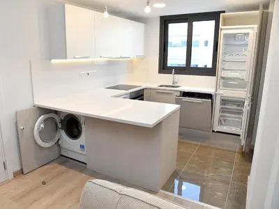 a kitchen with white cabinets and a washer and dryer at BAZ TOWER in Nicosia