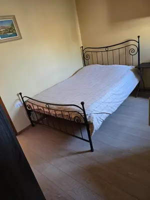 a bed in a room with a bed frame at City Center Holiday room in Limassol
