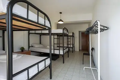 a room with three bunk beds and a desk at White Hostel in Limassol