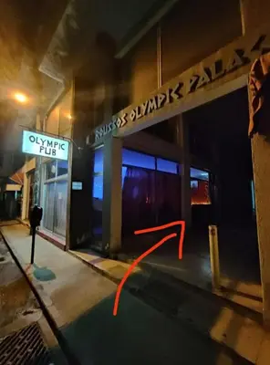 a building with a red arrow next to a parking meter at White Hostel in Limassol