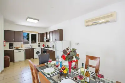 a kitchen and dining room with a dining table and a kitchen with aktop at Protaras View Villa 5 in Protaras