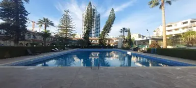 a large swimming pool with palm trees and buildings at Palm beach 14 in Limassol