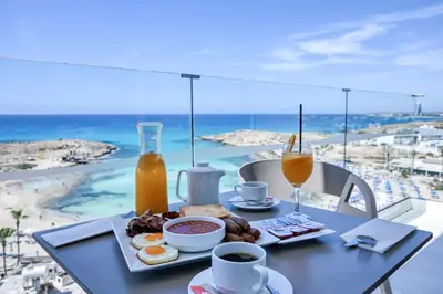 a table with breakfast food and a view of the beach at Chrysomare Beach Hotel & Resort in Ayia Napa