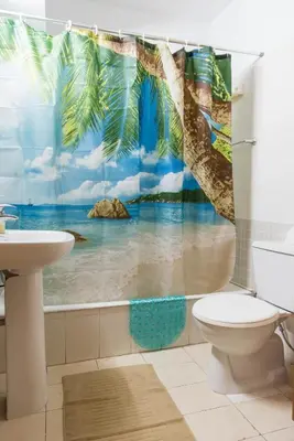 a bathroom with a tropical beach shower curtain at EURO CARISSA FLAT 101 in Larnaka