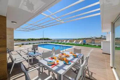 a patio with a table and chairs and a swimming pool at Infinity View Villa in Ayia Napa
