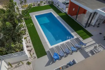 an overhead view of a swimming pool with chairs and a swimming pool at Colour Residences in Protaras