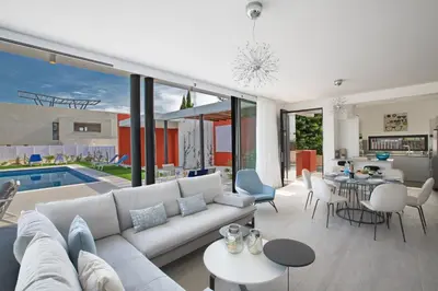 a living room with a white couch and a pool at Colour Residences in Protaras