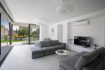 a living room with a couch and a tv at Colour Residences in Protaras