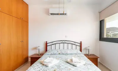a bedroom with a bed with two night stands and a window at Mediterranean dream in Voroklini