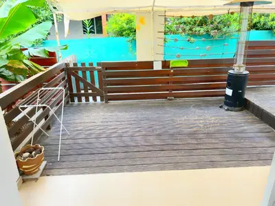 a porch with a wooden railing and a blue wall at Central 2 Bedroom Apt Terrace and Pool in Ayia Napa