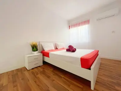 a white bedroom with a bed and a window at Central 2 Bedroom Apt Terrace and Pool in Ayia Napa