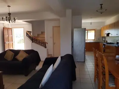 a living room with a couch and a kitchen at Sunrise Villa in Ayia Napa
