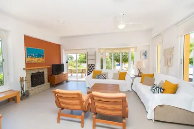 a living room with white furniture and a fireplace at Ayia Napa Villa Danae in Ayia Napa