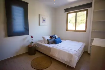 a bedroom with a bed with blue pillows and a window at Penthouse Duplex overlooking the Mediterranean in Larnaka