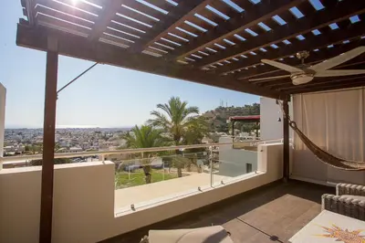 a balcony with a hammock and a view of the city at Penthouse Duplex overlooking the Mediterranean in Larnaka