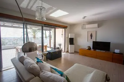 a living room with a couch and a television at Penthouse Duplex overlooking the Mediterranean in Larnaka