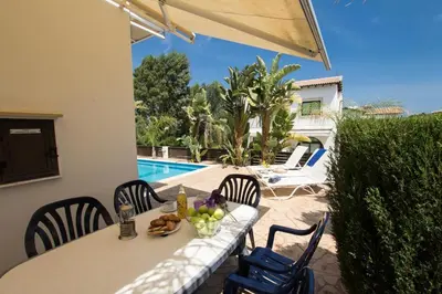 a table with fruit on it next to a pool at Villa Anatoli - Cape Greco in Protaras
