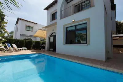 a villa with a swimming pool in front of a house at Villa Anatoli - Cape Greco in Protaras