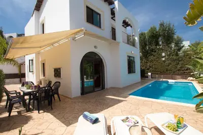 a villa with a swimming pool in front of a house at Villa Anatoli - Cape Greco in Protaras